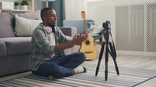 Young Adult Adjusting Camera and Recording Blog