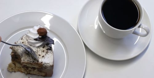 Slice of Cake and Coffee Being Eaten