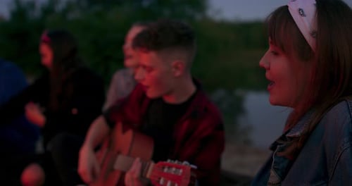 Friends Sing Around Bonfire at Night