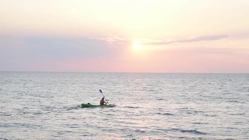 Excellent Summer Sunset on the Sea and the Silhouette of a Man on a Kayak.