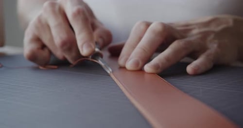 Hands Crafting Leather with Cutting Tool Close Up