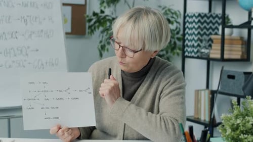 Woman Explaining Chemical Formula in Workplace Setting