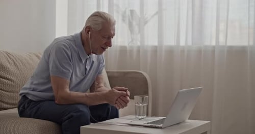 Senior Man Chatting on Laptop at Home