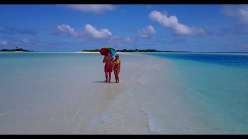 Man and lady sunbathe on relaxing shore beach voyage by blue ocean with white sandy background of th