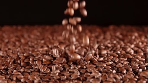 Kaffeebohnen heben sich auf einem Black BG vom Haufen ab