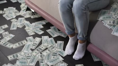 Woman Counting Money on Couch Surrounded by Cash