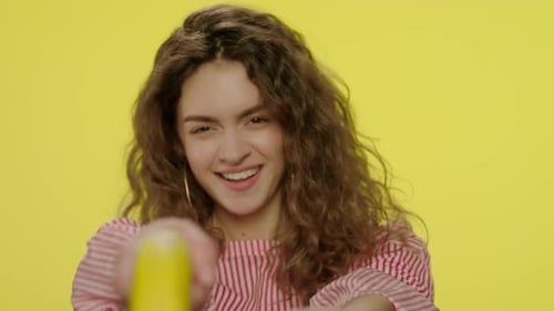 Smiling Woman Gesturing with a Banana