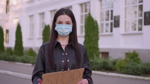 Woman Holding Stop Covid Sign With Mask