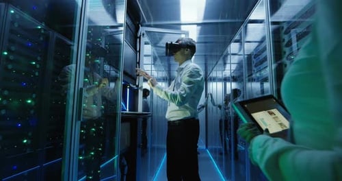Technician Works in a Data Center Wearing a VR Headset