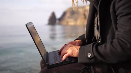 Typing on Laptop by the Sea