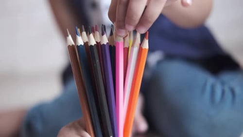 Hand Holding Colored Pencils and Picking One