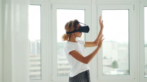 Woman Experiencing Virtual Reality in Bright Apartment