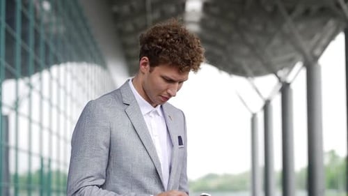 Handsome Businessman Calling on Mobile Phone Dialing Number and Talking on Smartphone Wearing