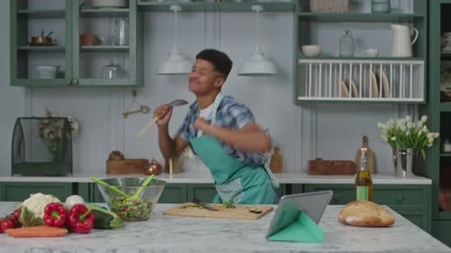 Young Adult Singing and Dancing in Kitchen