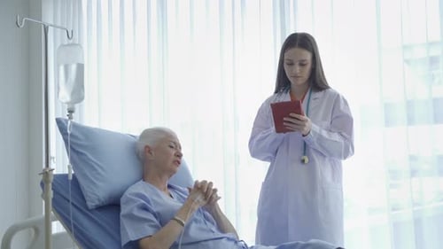 Doctor Talking to Senior Patient in Hospital Bed