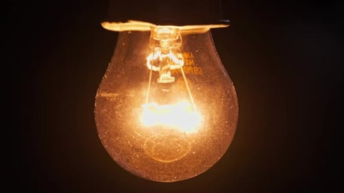 Light Bulb Slowly Turned On and Off on Black Background