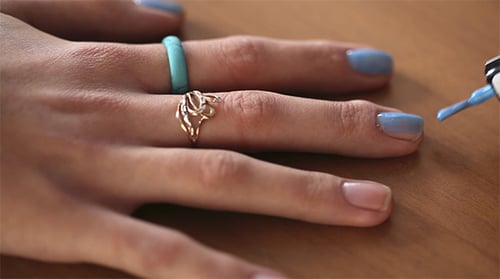 Hand Applying Blue Nail Polish Close Up