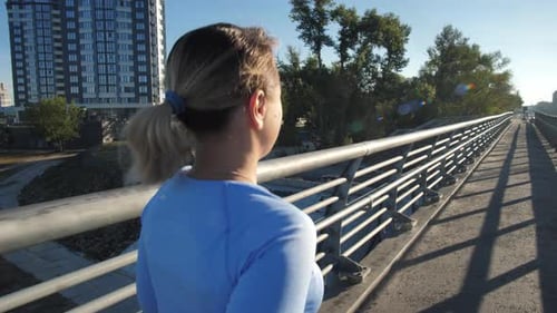 Fit Females Running Along Footpath of Urban Bridge
