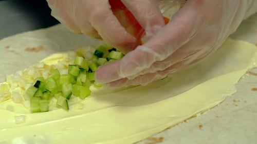 Close Up Hands Preparing a Wrap with Ingredients