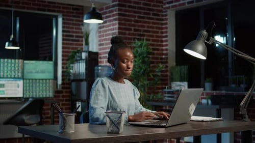 Woman Works on Computer Late at Night in Office