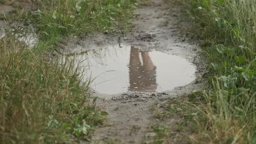 Close-up of Legs in Boots of Girl Running in Summer Rain Puddle