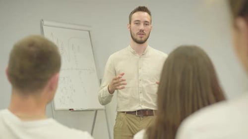 Selbstbewusster positiver Mann in formeller Kleidung hält Vorträge im Büro, der vor der Bürovorstand steht