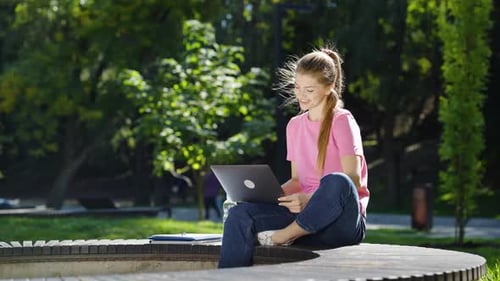 Student Having Zoom Event on Laptop in Park