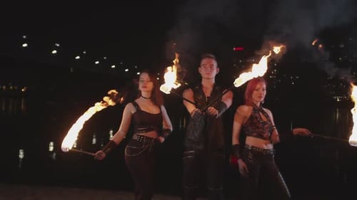 Fire Dancers Performing on Waterfront at Night