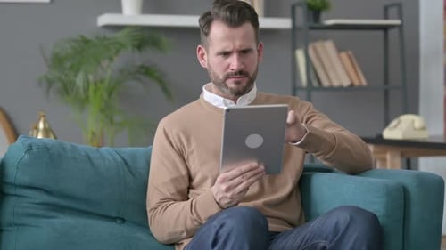 Man Reacts Negatively to Tablet Content Indoors