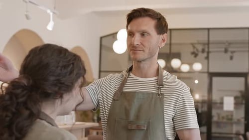 Male Bar Manager Talking to Waitress