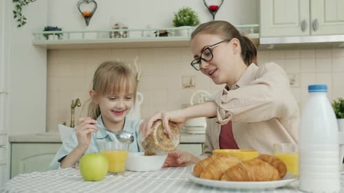 Woman Prepares Cereal for Child in Bright Kitchen