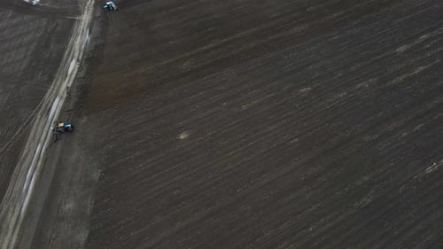 Aerial View of a Modern Blue Tractor Seeding Agricultural Field