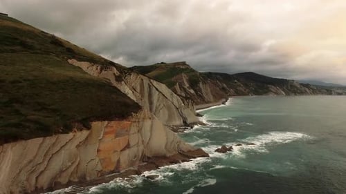 Stormy sea waves splashing on rocky cliff