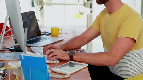Man Typing on Keyboard at Bright Workplace