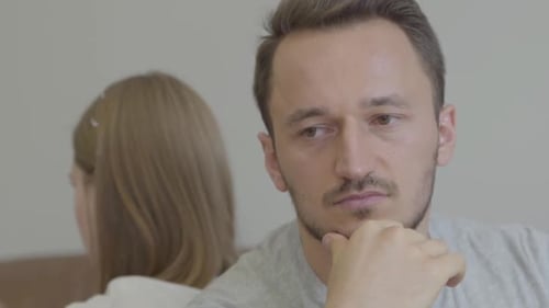 Close Up Portrait of Sad Man and Woman Sitting Back To Back with Unhappy Faces at Home