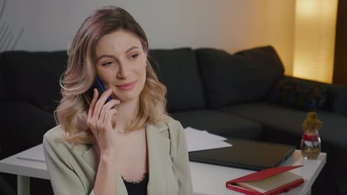 Woman Talking on Phone at Table
