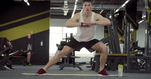 Young Man Stretching at the Gym