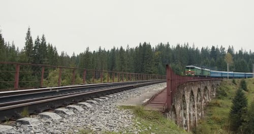 Train Goes Over the Bridge with an Old Stone Viaduct