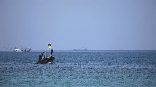 Longtail Boat Travels on Tropical Blue Ocean