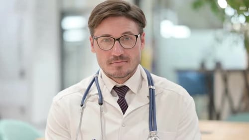 Serious Doctor with Glasses in Hospital Setting