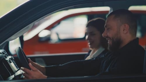 Couple exploring car touchscreen inside new vehicle
