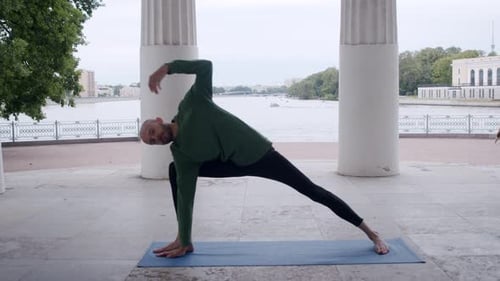 Yogi Performs Dog Snout Exercise Up in Open Space Against River Backdrop