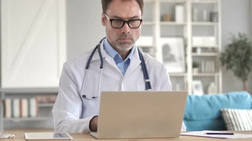 Senior Doctor Working on Laptop