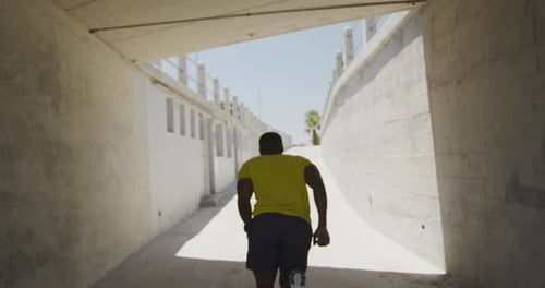 Man Running Through an Urban Concrete Tunnel