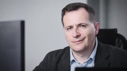 Adult Man Smiles in Office Setting