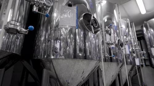 A câmera está se movendo ao longo do tanque moderno do brilho para triturar malte para a fabricação de cerveja na fábrica da cervejaria