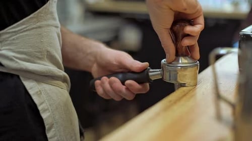 Barista Tamps Espresso Grinds for Coffee