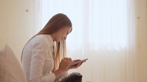 Smiling Woman Resting at Hotel Room with Mobile in Hands