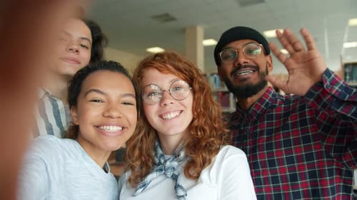 Multi-racial Group of Young People Taking Selfie in College Library Smiling