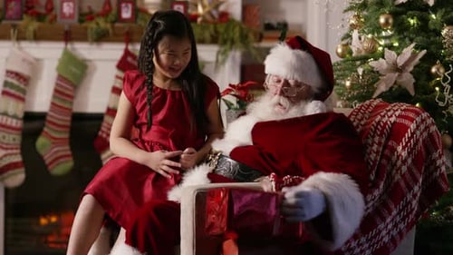 Child with Santa Claus Receives Christmas Gift